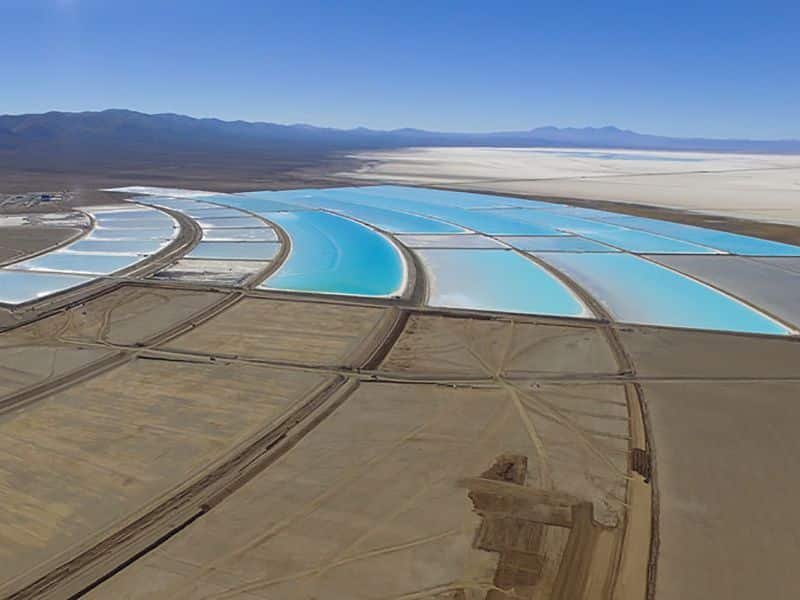 Toma aérea de un proyecto de explotación de litio en Argentina. Se ven montañas al fondo y grande piletas a lo largo del suelo