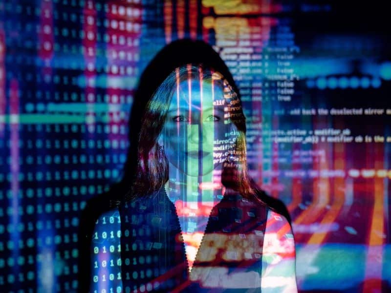 Una mujer frente a luces de computadora de inteligencia artificial