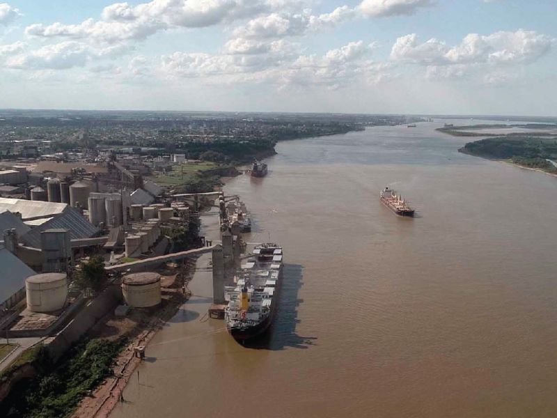 Foto aérea del río Paraná. Industrias en las orillas y barcos a lo largo del río.