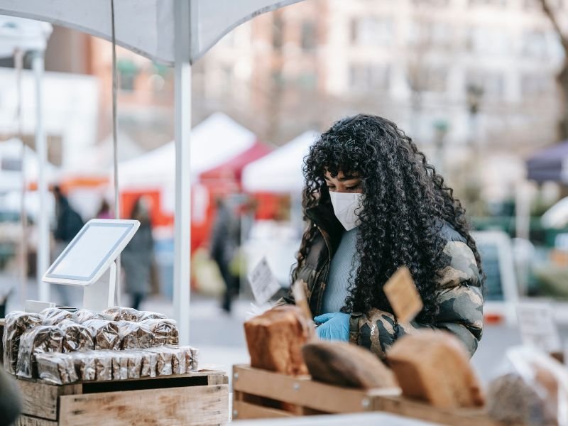 Una mujer compra pan en una feria de alimentos