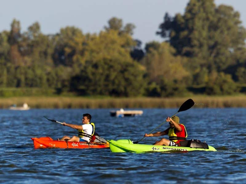 Dos hombres haciendo kayak en un lago