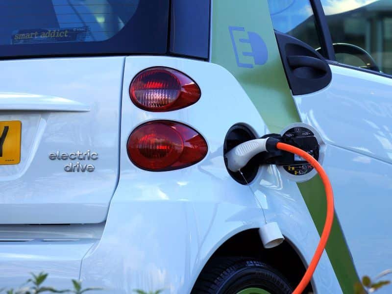 Un vehículo eléctrico blanco se recarga en una estación