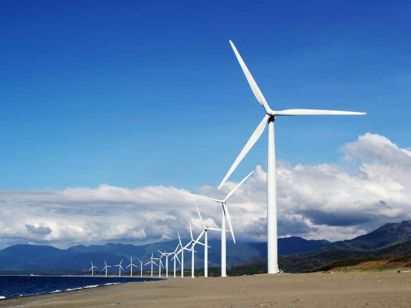 campo de energía eólica, grandes molinos de viento blanco en un lugar con montañas detrás