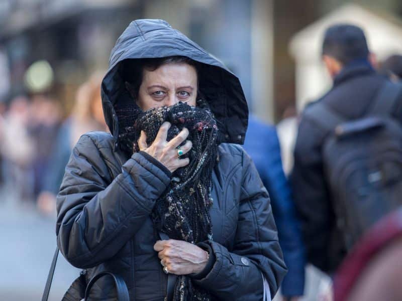 una mujer abrigada por el frio en la ciudad