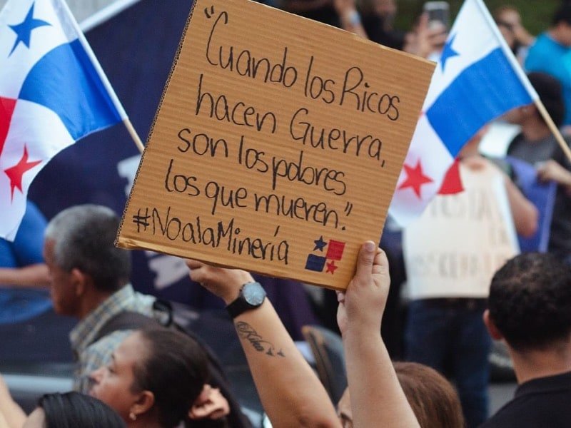 Un cartel en las protestas en Panamá contra la megaminería dice: “Cuando los ricos hacen guerra, son los pobres los que mueren. #NoALaMinería”.