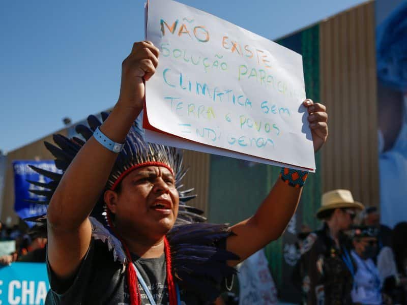 Un activista en la COP27 exigiendo justicia climática para los pueblos indígenas. El financiamiento es uno de los reclamos de la movilización.