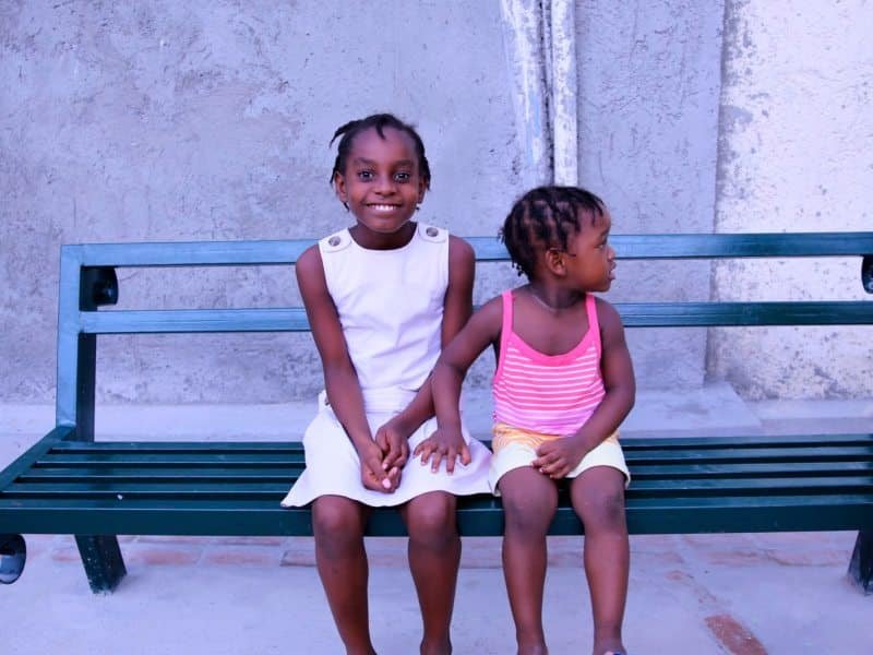 dos niñas de Haití, sentadas en un banco