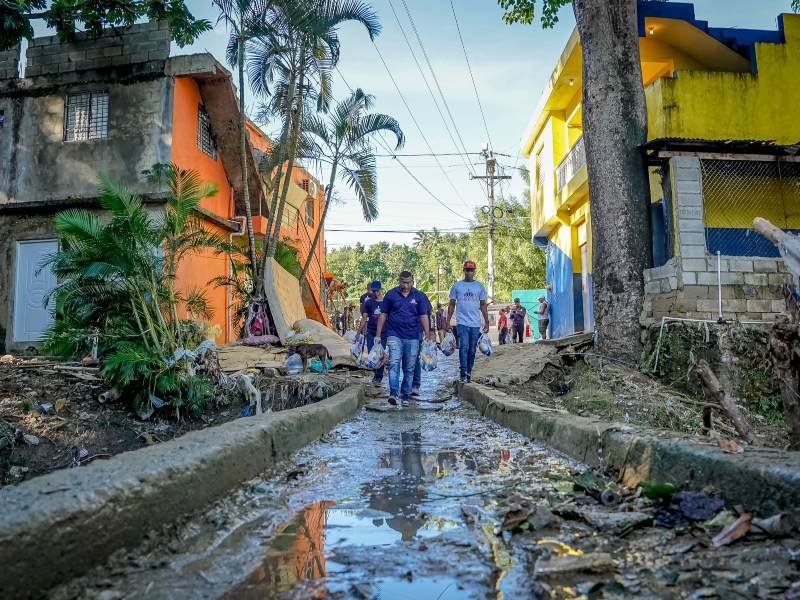 Personas enviadas por la presidencia de República Dominicana para distribuir raciones alimenticias a familias afectadas por las inundaciones en todo el país.