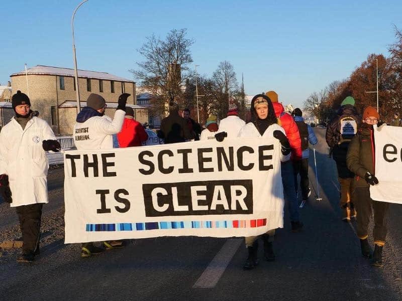 movilización de científicos con carteles. Uno dice: "La ciencia es clara", en referencia al cambio climático.