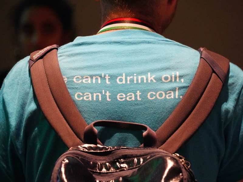 En la COP28, un participante usa una remera que tiene una leyenda que dice: "No puedo beber petróleo".