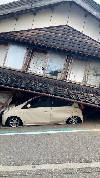Un coche queda atrapado bajo una casa derrumbada tras el terremoto, en la ciudad de Shika, prefectura de Ishikawa, Japón 1 de enero de 2024, en esta foto difundida por Kyodo.