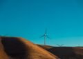 Parque eólico en paisaje desértico al atardecer, símbolo de la expansión de energía verde en regiones remotas de China.