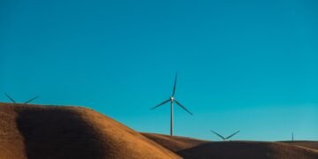 Parque eólico en paisaje desértico al atardecer, símbolo de la expansión de energía verde en regiones remotas de China.