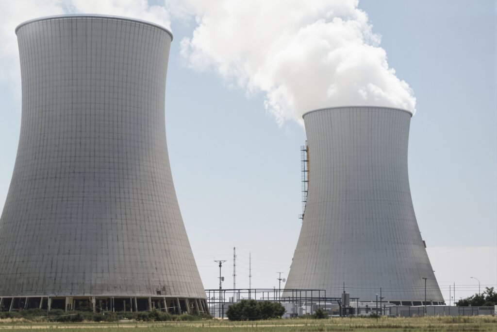 Torres de refrigeración de una central térmica en proceso de demolición con humo y escombros.