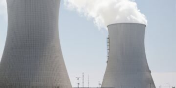 Torres de refrigeración de una central térmica en proceso de demolición con humo y escombros.