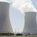 Torres de refrigeración de una central térmica en proceso de demolición con humo y escombros.