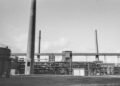 Refinería petrolera de mediados del siglo XX con chimeneas emitiendo humo, época en que gobiernos conocían riesgos del calent
