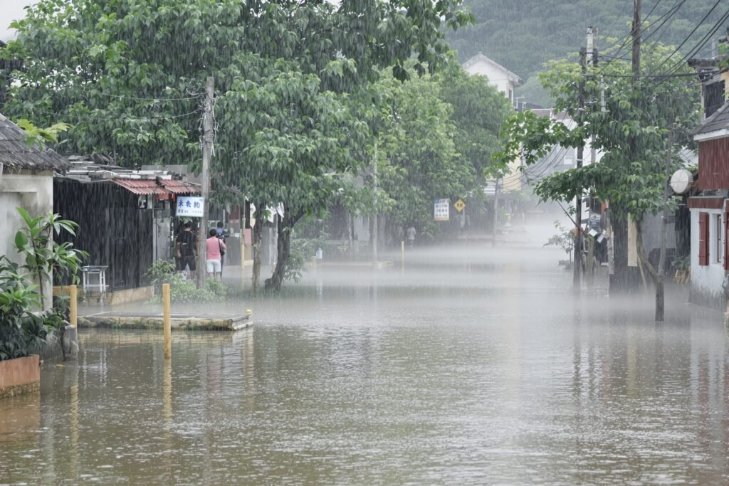 Calles inundadas en una aldea del sur de China tras el paso de un tifón, con aguas cubriendo viviendas.