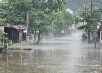 Calles inundadas en una aldea del sur de China tras el paso de un tifón, con aguas cubriendo viviendas.