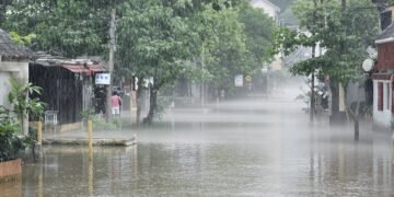 Calles inundadas en una aldea del sur de China tras el paso de un tifón, con aguas cubriendo viviendas.