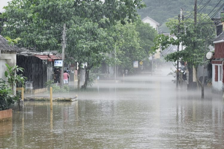 Calles inundadas en una aldea del sur de China tras el paso de un tifón, con aguas cubriendo viviendas.