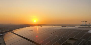 Paneles solares instalados en tejados en África bajo el sol del atardecer.