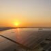 Paneles solares instalados en tejados en África bajo el sol del atardecer.