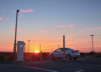 Estación de carga para vehículos eléctricos al atardecer, símbolo de la transición hacia la movilidad eléctrica en Sudamérica