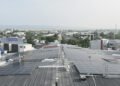 Paneles solares en techos de casas de barrio residencial australiano con baterías de almacenamiento.
