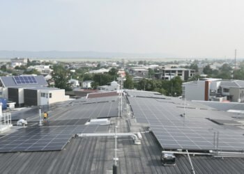 Paneles solares en techos de casas de barrio residencial australiano con baterías de almacenamiento.