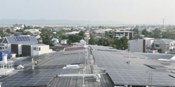 Paneles solares en techos de casas de barrio residencial australiano con baterías de almacenamiento.