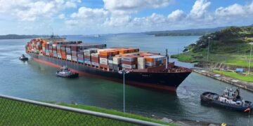 Vista de las esclusas del Canal de Panamá con embarcaciones en tránsito bajo cielo despejado.