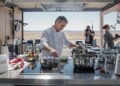 Chef profesional cocinando en cocina moderna con tecnología de inducción eléctrica.