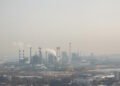 Paisaje industrial con smog en China, donde nueva ley impone responsabilidad vitalicia a funcionarios por daño ambiental.