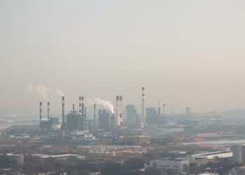 Paisaje industrial con smog en China, donde nueva ley impone responsabilidad vitalicia a funcionarios por daño ambiental.