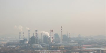 Paisaje industrial con smog en China, donde nueva ley impone responsabilidad vitalicia a funcionarios por daño ambiental.