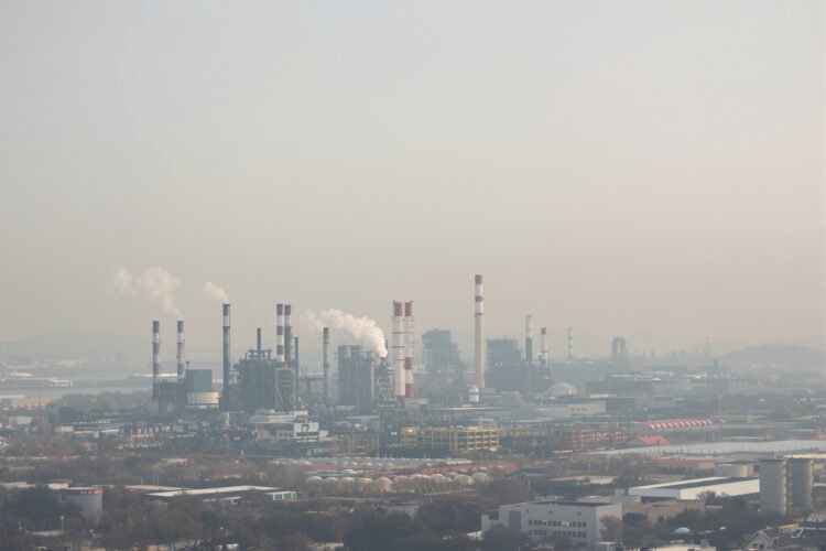 Paisaje industrial con smog en China, donde nueva ley impone responsabilidad vitalicia a funcionarios por daño ambiental.