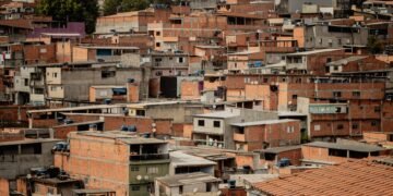 Vista aérea de una favela en São Paulo, Brasil, mostrando viviendas densamente construidas sin vegetación.