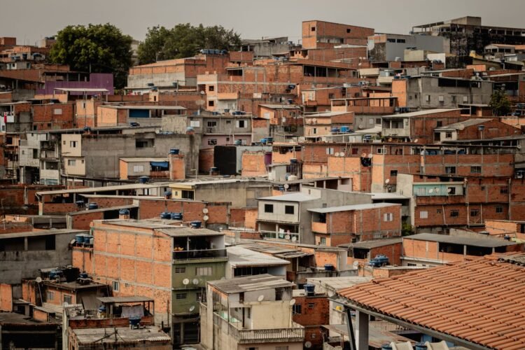 Vista aérea de una favela en São Paulo, Brasil, mostrando viviendas densamente construidas sin vegetación.