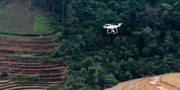 Dron sobrevolando terreno deforestado listo para la reforestación con tecnología de siembra aérea.