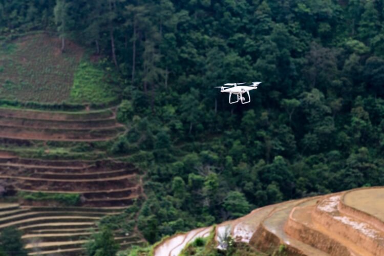 Dron sobrevolando terreno deforestado listo para la reforestación con tecnología de siembra aérea.