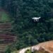 Dron sobrevolando terreno deforestado listo para la reforestación con tecnología de siembra aérea.