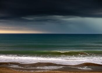 Olas de tormenta tropical golpeando la costa de Hawái bajo cielos nublados durante el paso del huracán Lala.