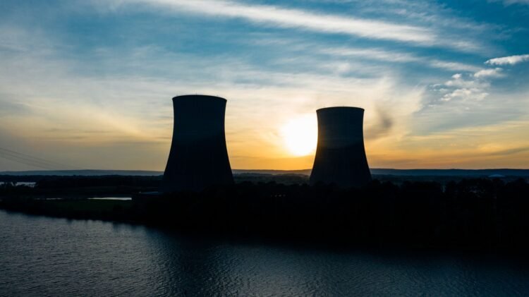 Torres de enfriamiento de planta nuclear al atardecer, infraestructura afectada por olas de calor en Europa.