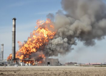 Columna de humo elevándose desde un incendio industrial en zona petrolera.