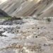 Valle del Himalaya con aguas turbias de inundación tras crecida repentina en zona montañosa de Nepal