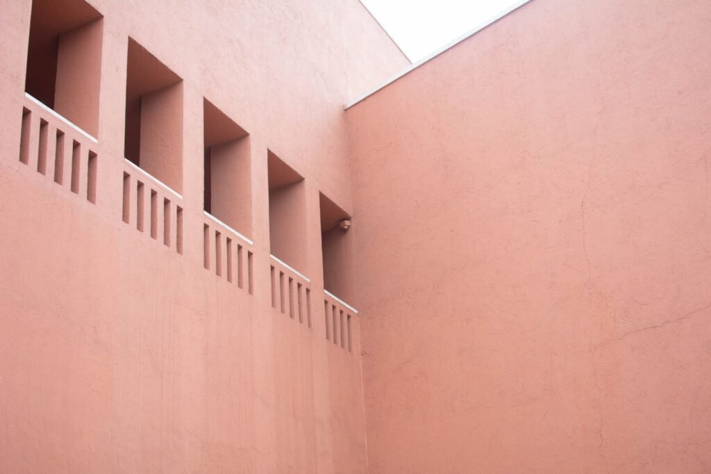 Fachada de arcilla terracota con textura porosa, material usado en sistemas de enfriamiento pasivo en India.