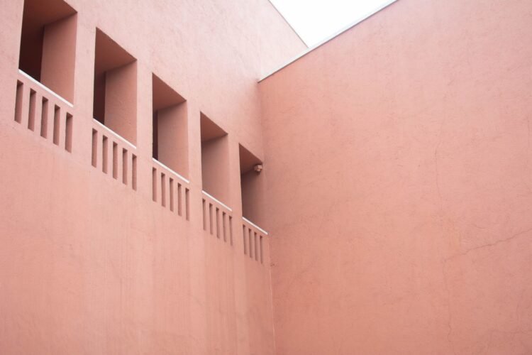Fachada de arcilla terracota con textura porosa, material usado en sistemas de enfriamiento pasivo en India.