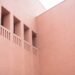 Fachada de arcilla terracota con textura porosa, material usado en sistemas de enfriamiento pasivo en India.