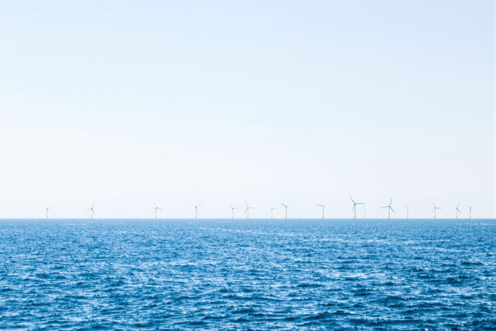 Parque eólico marino en el mar del Norte con aerogeneradores sobre el océano al atardecer.